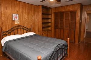 a bedroom with a bed in a room with wooden walls at Mid-City Rustic Retreat in Baton Rouge