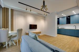 a living room and kitchen with a couch and a table at Luxor Collection Apartments in Tbilisi City