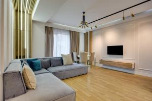 a living room with a couch and a flat screen tv at Luxor Collection Apartments in Tbilisi City
