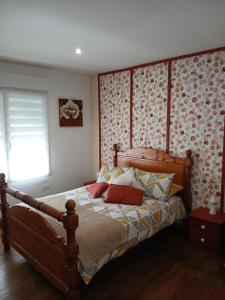 a bedroom with a bed with a wooden headboard at Les 4 Portes in Le Mesnillard