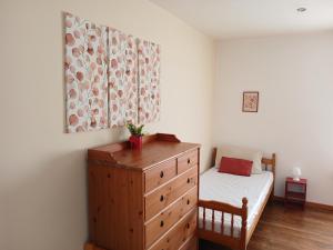 a bedroom with a wooden dresser and a bed at Les 4 Portes in Le Mesnillard