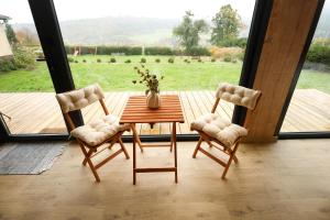 a table and two chairs in a room with a view at ermiglamping in Jince