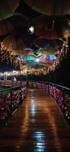 a boardwalk with umbrellas on a pier at night at Casa no Bosque Vila Natal in Campos do Jordão +42 photos