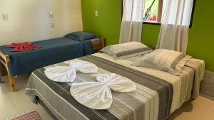two beds in a room with green walls at Pousada Cantinho da Mata in Paraty