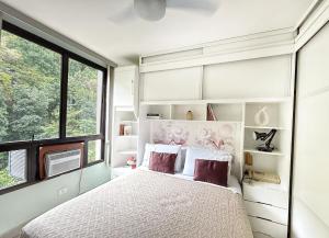 a bedroom with a bed and a large window at SUÍTE EM COPACABANA - APART HOTEL 200m DA PRAIA, PISCINA, ACADEMIA in Rio de Janeiro