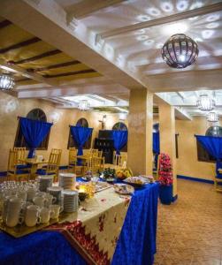 een tafel in een kamer met een blauwe tafeldoek bij SUD-EST palace in Aït Igad