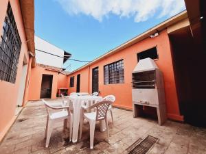 a patio with a table and chairs and an oven at Casa 4 quartos no centro da cidade - 3 vagas de garagem in Campo Grande