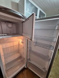 an empty refrigerator with its door open in a kitchen at Casa 4 quartos no centro da cidade - 3 vagas de garagem in Campo Grande