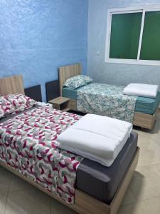 a bedroom with two twin beds and a window at appartement fes in Fès