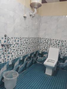 a bathroom with a toilet and a sink in it at Prithvi hotel and restaurant in Mussoorie