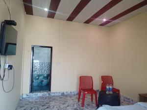 a room with two red chairs and a mirror at Prithvi hotel and restaurant in Mussoorie