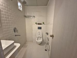 Niwaas Stay في فاراناسي: حمام أبيض مع مرحاض ومغسلة