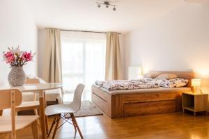 a bedroom with a bed and a table and a dining room at Apartmán IRIS Poděbrady 2 in Nymburk