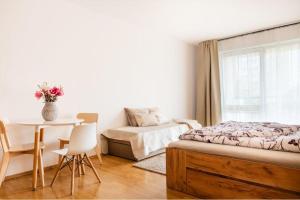 a bedroom with a bed and a table and a chair at Apartmán IRIS Poděbrady 2 in Nymburk
