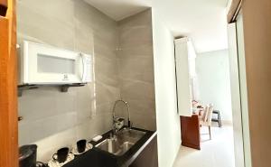 a kitchen with a sink and a microwave at SUÍTE EM COPACABANA - APART HOTEL 200m DA PRAIA, PISCINA, ACADEMIA in Rio de Janeiro +21 photos
