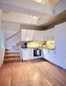 トロンハイムにあるSpacious and modern apartment in the heart of the cityの白いキャビネットと階段付きのキッチン