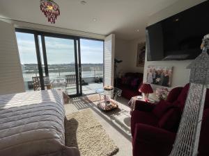 a living room with a couch and a large window at Special Occasion, Stunning sea view balconied suite in Shoreham-by-Sea