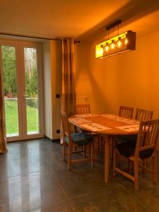 a dining room with a wooden table and chairs at Le Goulet in Prémanon