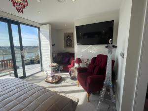 a bedroom with a bed and a television and a guitar at Special Occasion, Stunning sea view balconied suite in Shoreham-by-Sea +22 photos