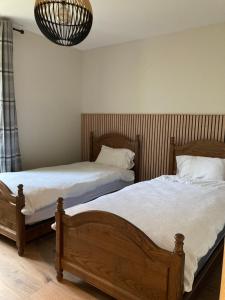 a bedroom with two beds and a chandelier at Le Goulet in Prémanon
