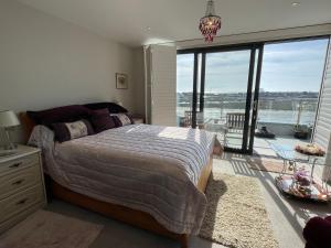 a bedroom with a bed and a large window at Special Occasion, Stunning sea view balconied suite in Shoreham-by-Sea