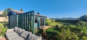 a blue tiny house in a yard with a couch at Chalet cosy avec vue imprenable in Le Luc