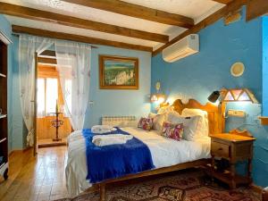 a bedroom with a large bed with blue walls at Hotel Peruskenea in Jaunsaras