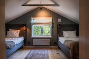 a attic room with two beds and a window at Annexet Orrabackens in Järvsö