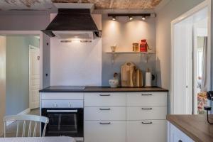 a kitchen with white cabinets and a stove at Annexet Orrabackens in Järvsö