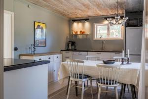a kitchen with a table and chairs in a kitchen at Annexet Orrabackens in Järvsö