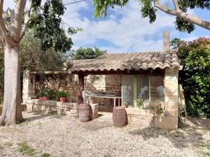 une maison en pierre avec une table et un arbre dans l'établissement les Micocouliers, à La Celle-sous-Gouzon