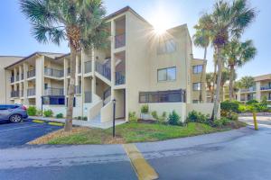 - un grand immeuble avec des palmiers devant dans l'établissement Beachside St Augustine Resort Condo, 6 Mi to Dtwn!, à Coquina Gables