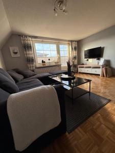 una sala de estar con un sofá y una mesa en Haus Inseltraum, en Fehmarn