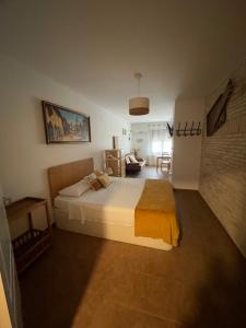 a bedroom with a bed and a living room at Apartahotel Belchite in Belchite