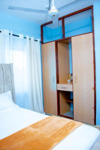 Un dormitorio con una cama y una puerta corrediza de vidrio. en Zana homes, en Kilifi