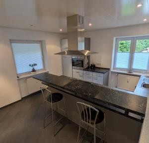 a kitchen with a large counter with bar stools at Casa Viva in Niederdorla