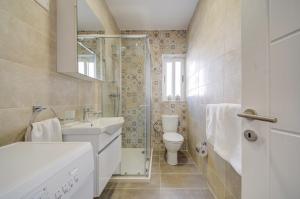 a bathroom with a toilet and a sink and a shower at Dar One - Self catering & self check in apartments by Tritoni Hotels in Il-Gżira +30 photos