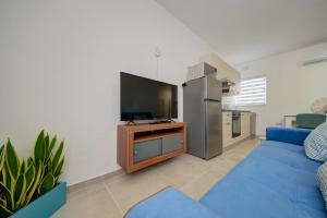 a living room with a blue couch and a tv at Dar One - Self catering & self check in apartments by Tritoni Hotels in Il-Gżira