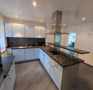 a kitchen with white cabinets and granite counter tops at Casa Viva in Niederdorla