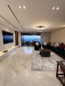 a living room with a couch and a flat screen tv at Lumen Residence in Cairo