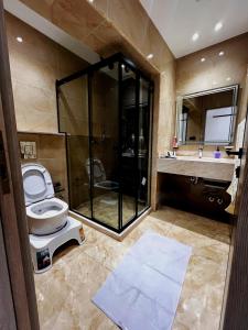 a bathroom with a toilet and a shower and a sink at Lumen Residence in Cairo +13 photos