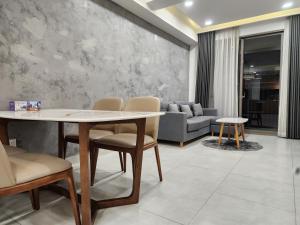 ein Esszimmer mit Tisch und Stühlen und einer Couch in der Unterkunft Lang Retreat Apartment - Resort Pool & Elite Gym in Ho-Chi-Minh-Stadt