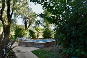 a swimming pool in a yard with trees at Maison en pierre rénovée avec jardin et piscine privative chauffée in Hyères
