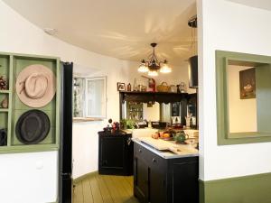 a kitchen with black cabinets and a hat on the wall at Maison en pierre rénovée avec jardin et piscine privative chauffée in Hyères