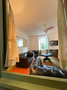a living room with a leather couch and a table at Maison en pierre rénovée avec jardin et piscine privative chauffée in Hyères +14 photos