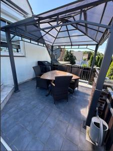 Un patio con una mesa y sillas bajo una sombrilla. en Haus Inseltraum, en Fehmarn