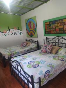two beds in a room with green walls at Hotel casa reina in Ibagué