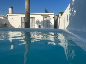 ein Wasserbecken vor einem weißen Haus in der Unterkunft Las Cumbres 1 in El Puerto de Santa María