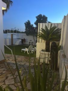 eine Terrasse mit Stühlen, einem Tisch und einer Pflanze in der Unterkunft Las Cumbres 1 in El Puerto de Santa María