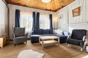 a living room with a blue couch and two chairs at Chalupa pod stromy in Kovářská